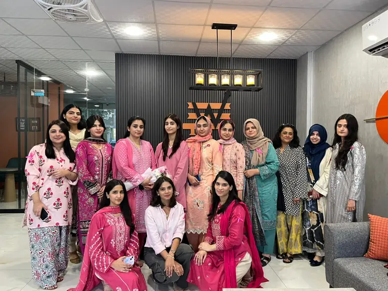 Women in colorful traditional dress posing together in the lobby