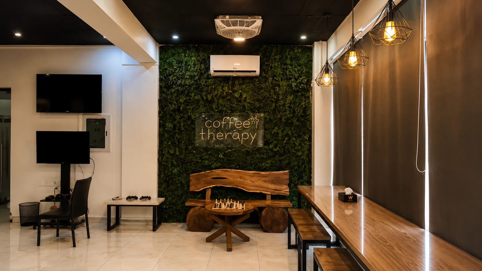 The coffee therapy room with its plant wall, neon script, live-edge bench and chess set
