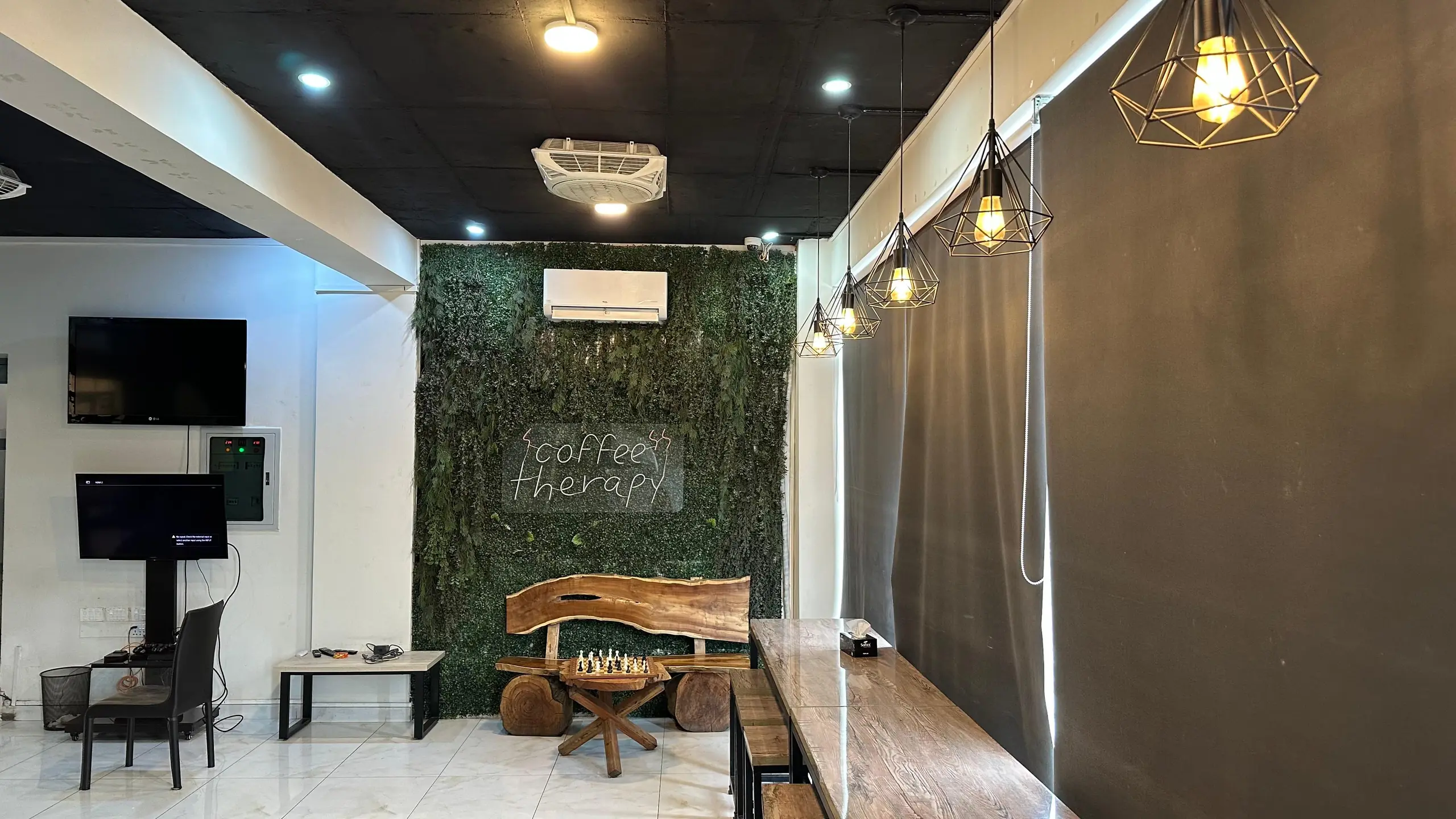 The coffee therapy room with its plant wall, neon script, live-edge bench and chess set
