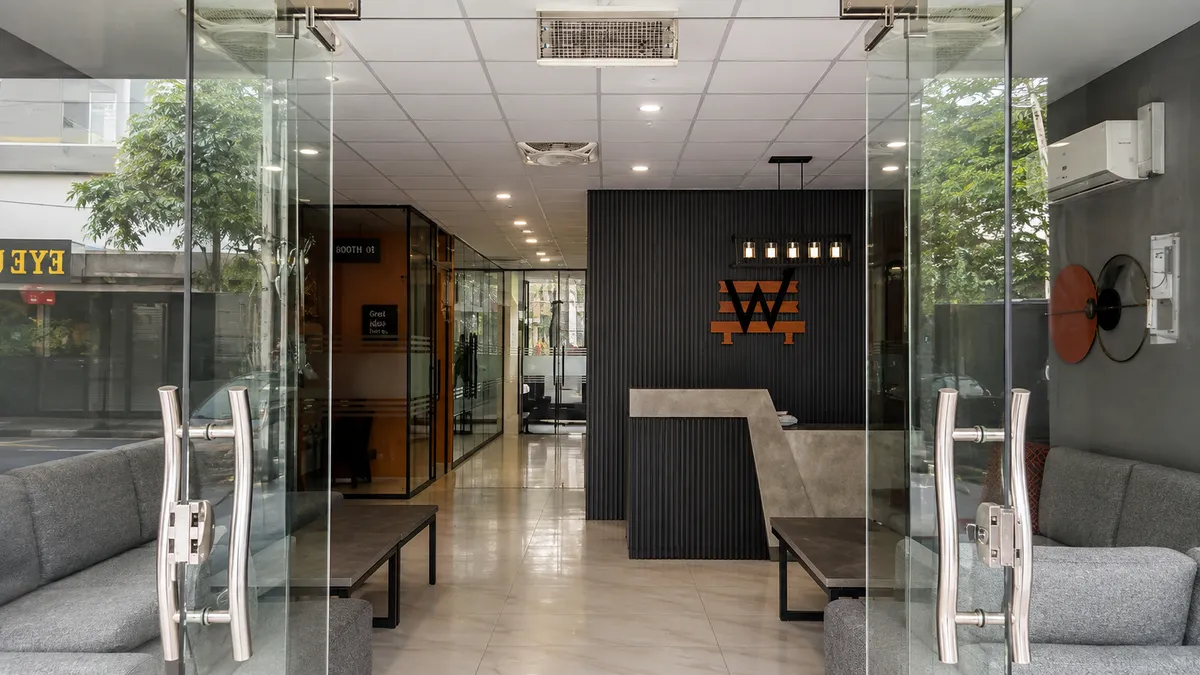Looking in through the glass street doors of WorkBench to the reception desk and the amber W on the fluted wall