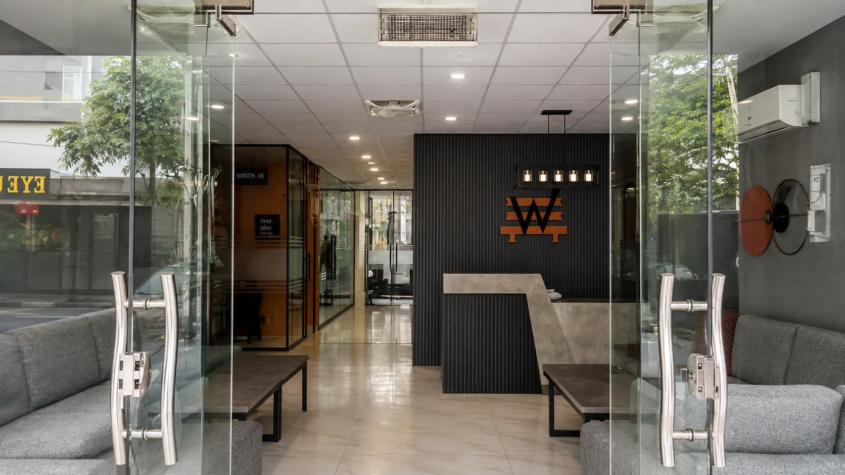 Looking in through the glass street doors to the reception desk and the amber W on the fluted wall